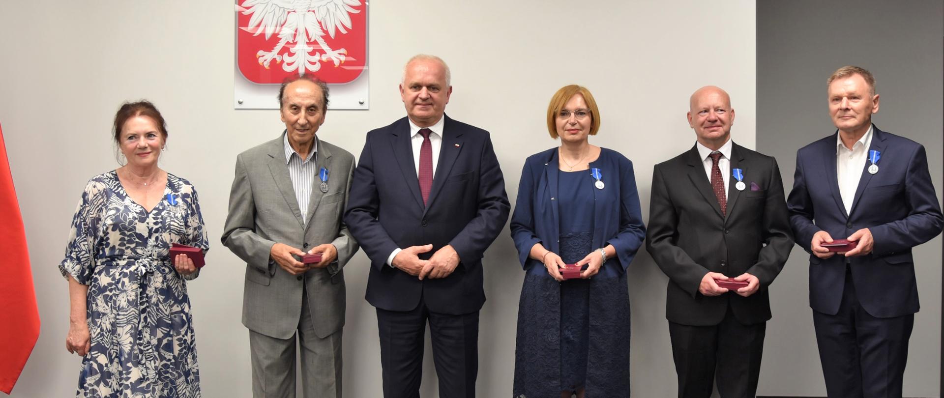 Do wspólnego zdjęcia pozują odznaczeni i wojewoda. 