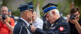 Na zdjęciu druh OSP odznaczmy przez Małopolskiego Kapelana strażaków obaj strażacy w mundurach galowych koloru granatowego. 