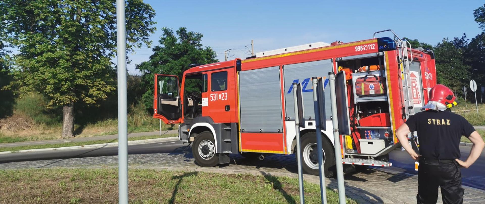 Samochód pożarniczy stoi na rondzie.