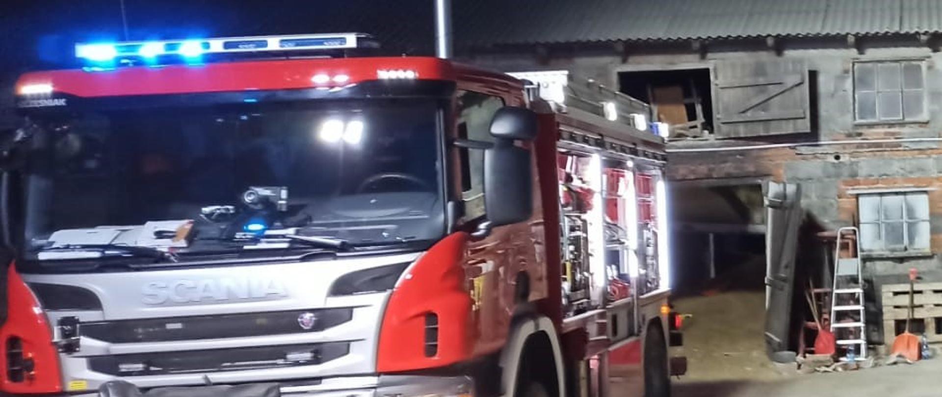 Samochód Strażacki, w tle budynek gospodarczy