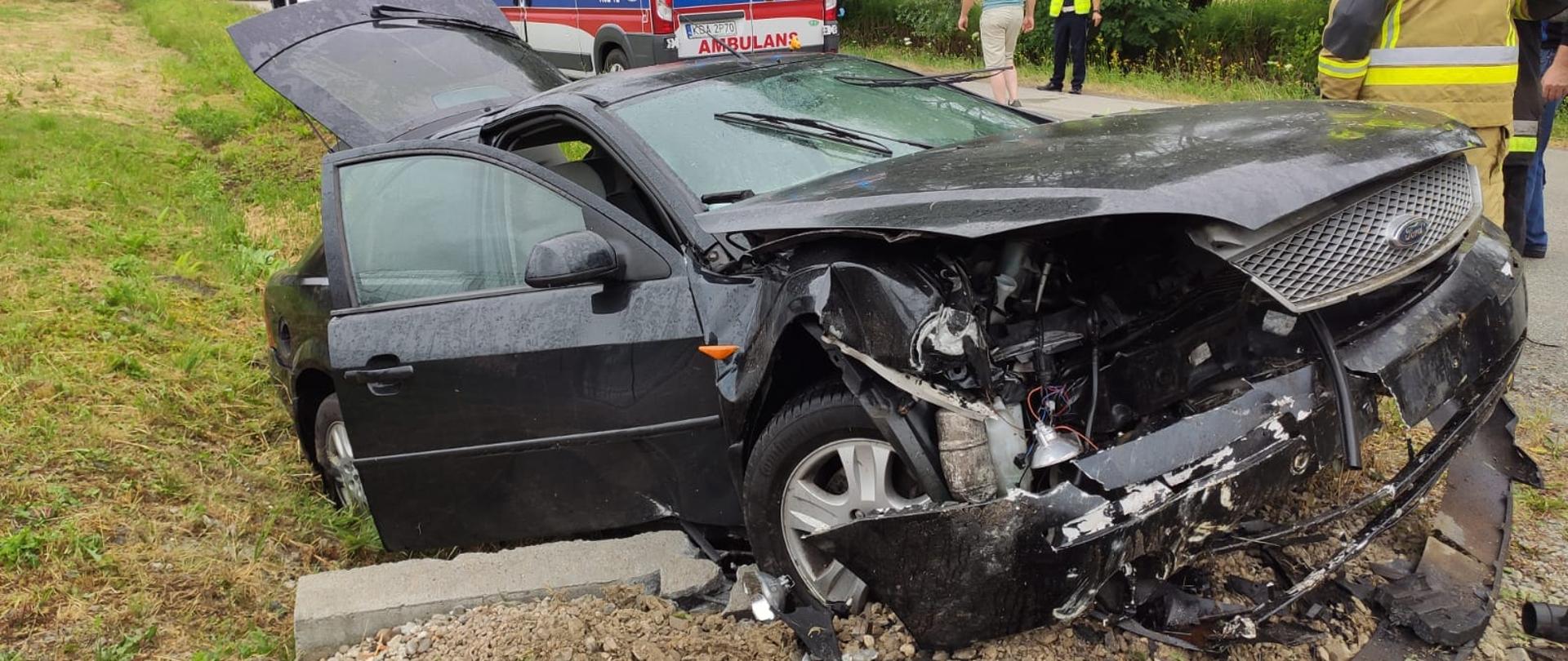 Na zdjęciu widać rozbity samochód, który zatrzymał się na mostku. Karetka, straż pożarna i policja.