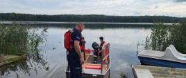 Zdjęcie przedstawia funkcjonariuszy Policji i Państwowej Straży Pożarnej w łodzi płaskodennej podczas patrolu kąpielisk na terenie powiatu człuchowskiego
