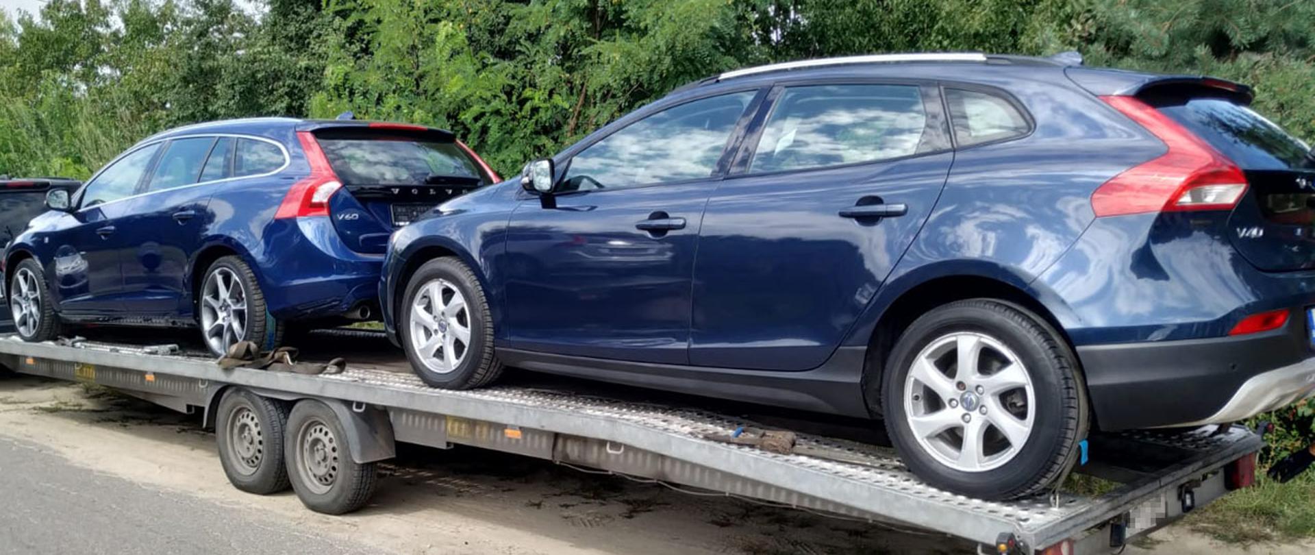 Dwa granatowe samochody na lawecie