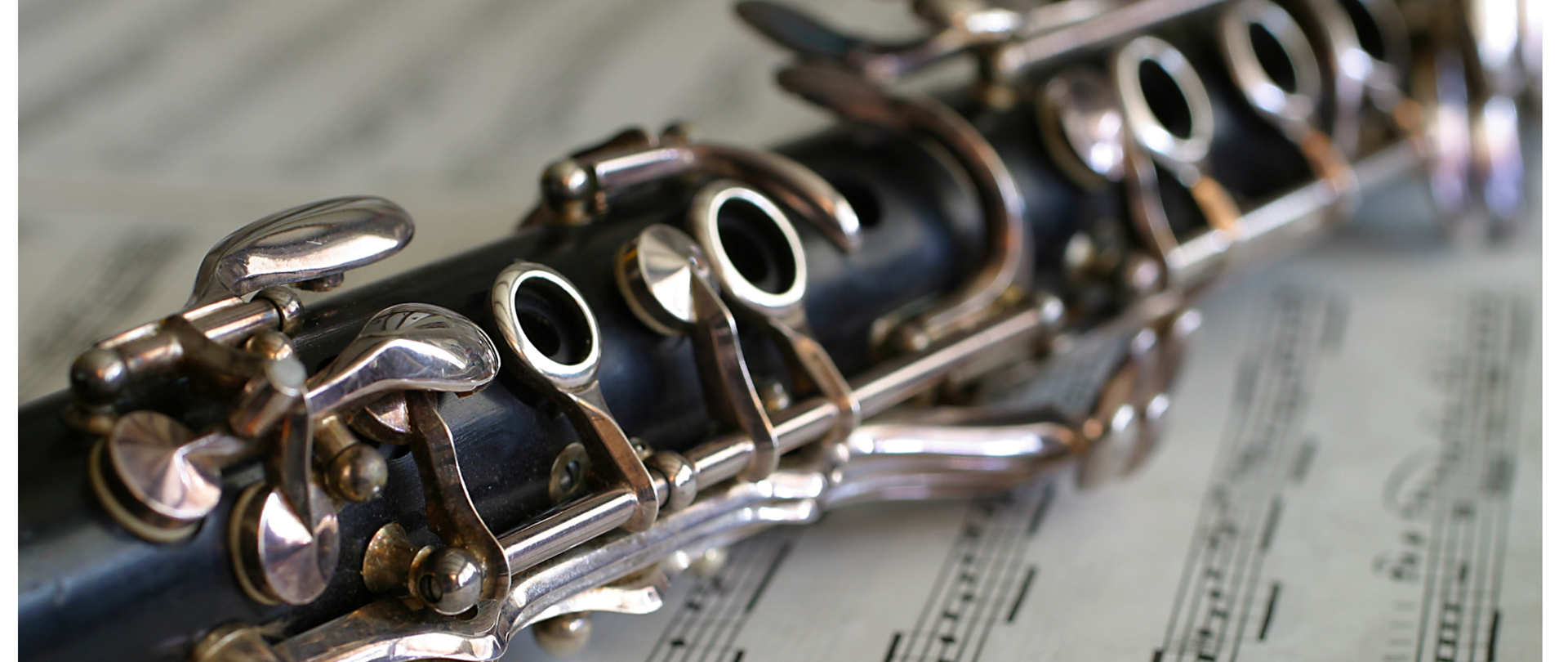 Plakat zapowiadający warsztaty klarnetowe, na białym tle, na środku zdjęcie klarnetu leżącego na zapisie nutowym-nad zdjęciem informacja „warsztaty klarnetowe, poprowadzi Michał Rymarz z ZSM w Krośnie”, pod zdjęciem napis „5 maja godz. 17:00 aula PSM, zapraszamy uczniów, rodziców i nauczycieli”, logo szkoły.