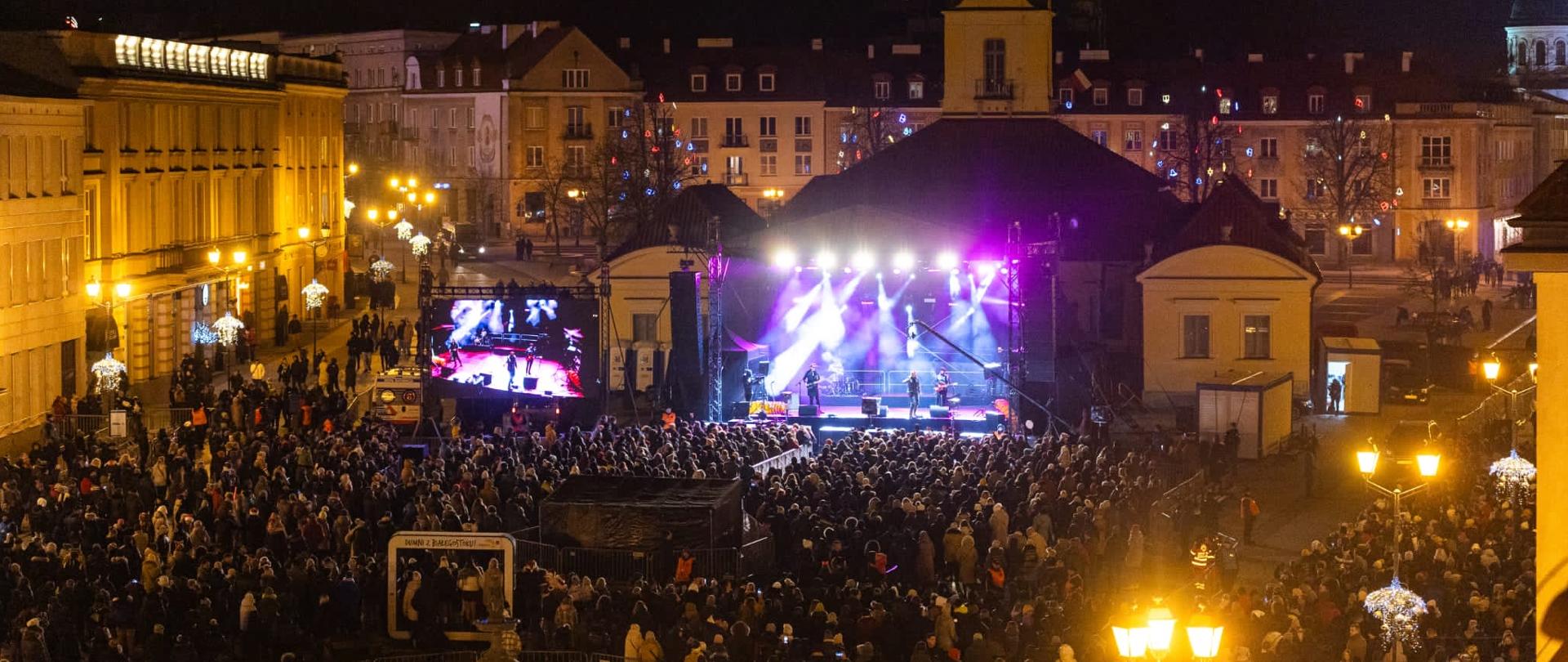 Scena sylwestrowa na tle ratusza. Przed sceną mieszkańcy