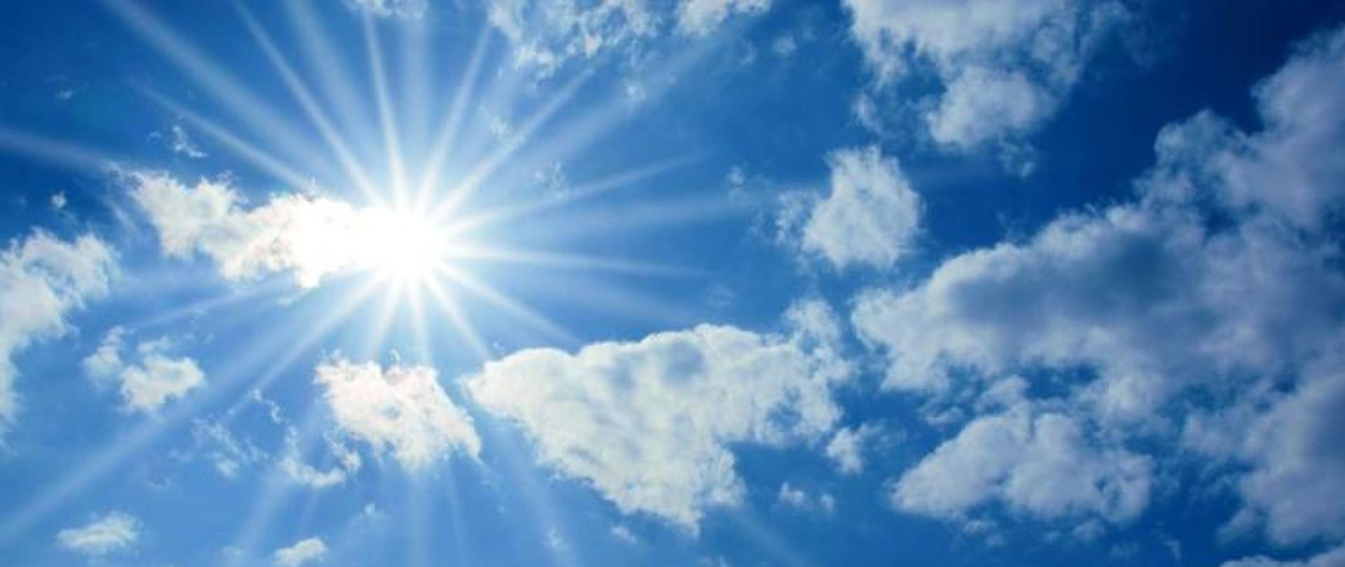 zdjęcie słońca na tle częściowo zachmurzonego niebieskiego nieba.