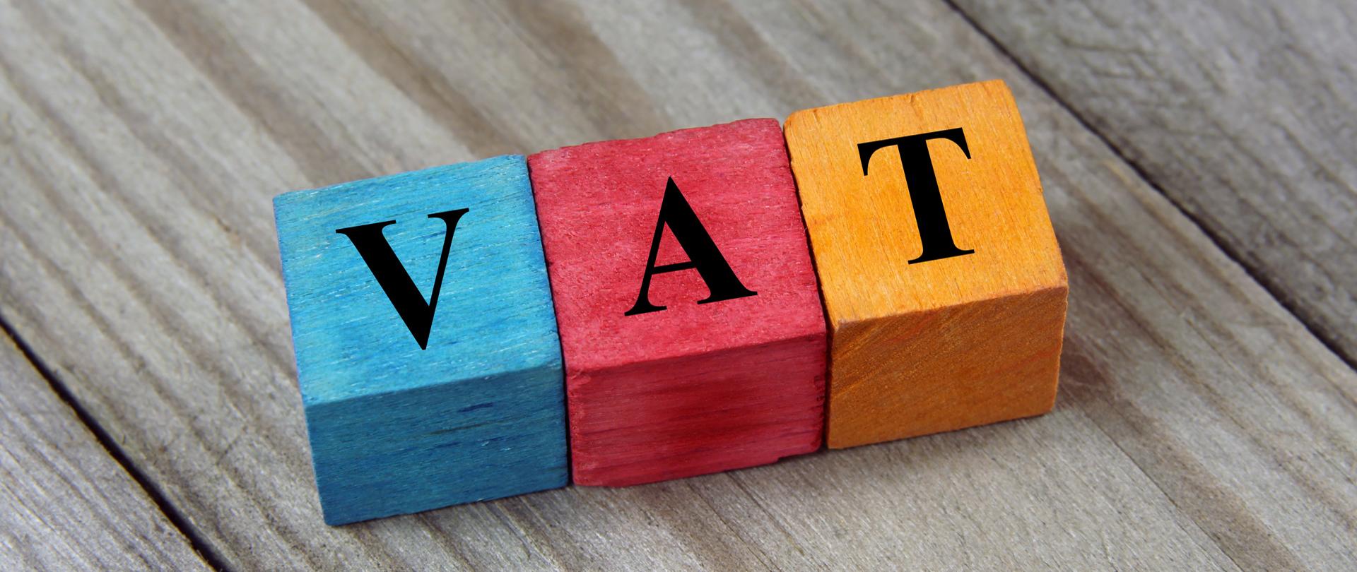 Kolorowe klocki z literami ułożonymi w napis VAT.