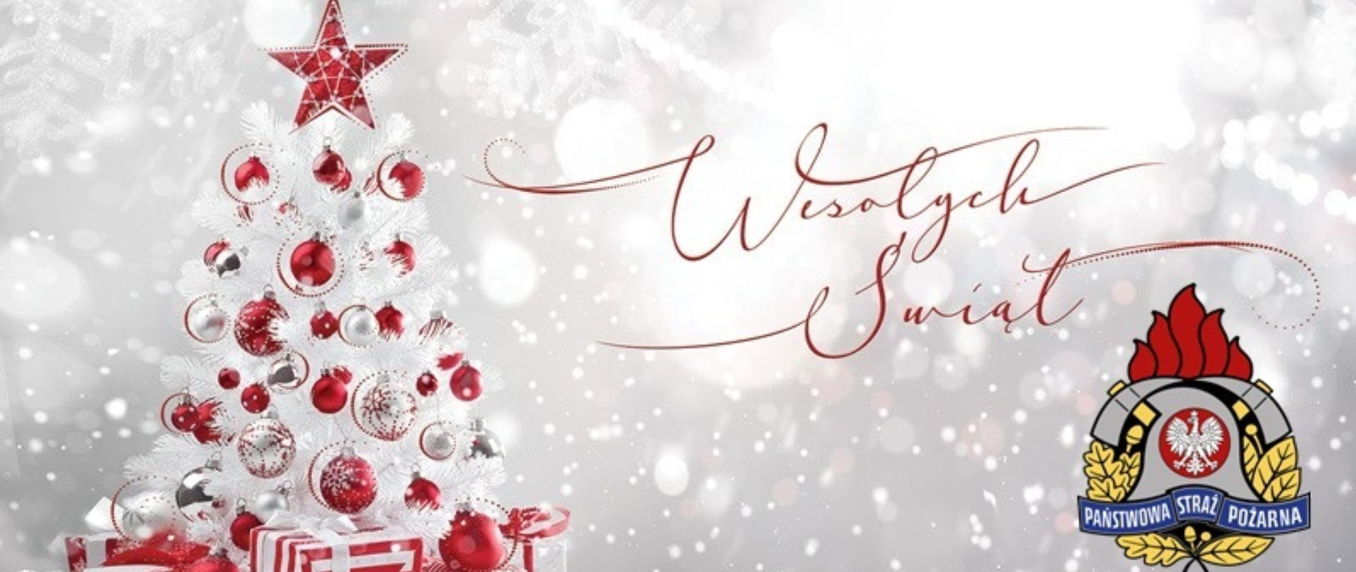 Panoramiczna kartka bożonarodzeniowa w jasnej, zimowej kolorystyce. Po lewej stronie znajduje się biała choinka udekorowana czerwonymi i srebrnymi bombkami, z czerwoną gwiazdą na szczycie oraz prezentami u podstawy. W tle widoczny jest efekt padającego śniegu. Po prawej stronie umieszczono napis „Wesołych Świąt” wykonany ozdobną czcionką oraz logo Państwowej Straży Pożarnej. Na dole grafiki widnieje czerwony napis: „Komenda Miejska Państwowej Straży Pożarnej w Ostrołęce”.