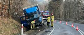 Samochód ciężarowy w rowie a obok strażacy