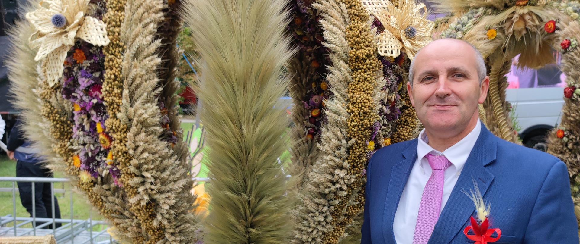 Kierownik Oddziału w Łęcznej na tle wieńca dożynkowego.