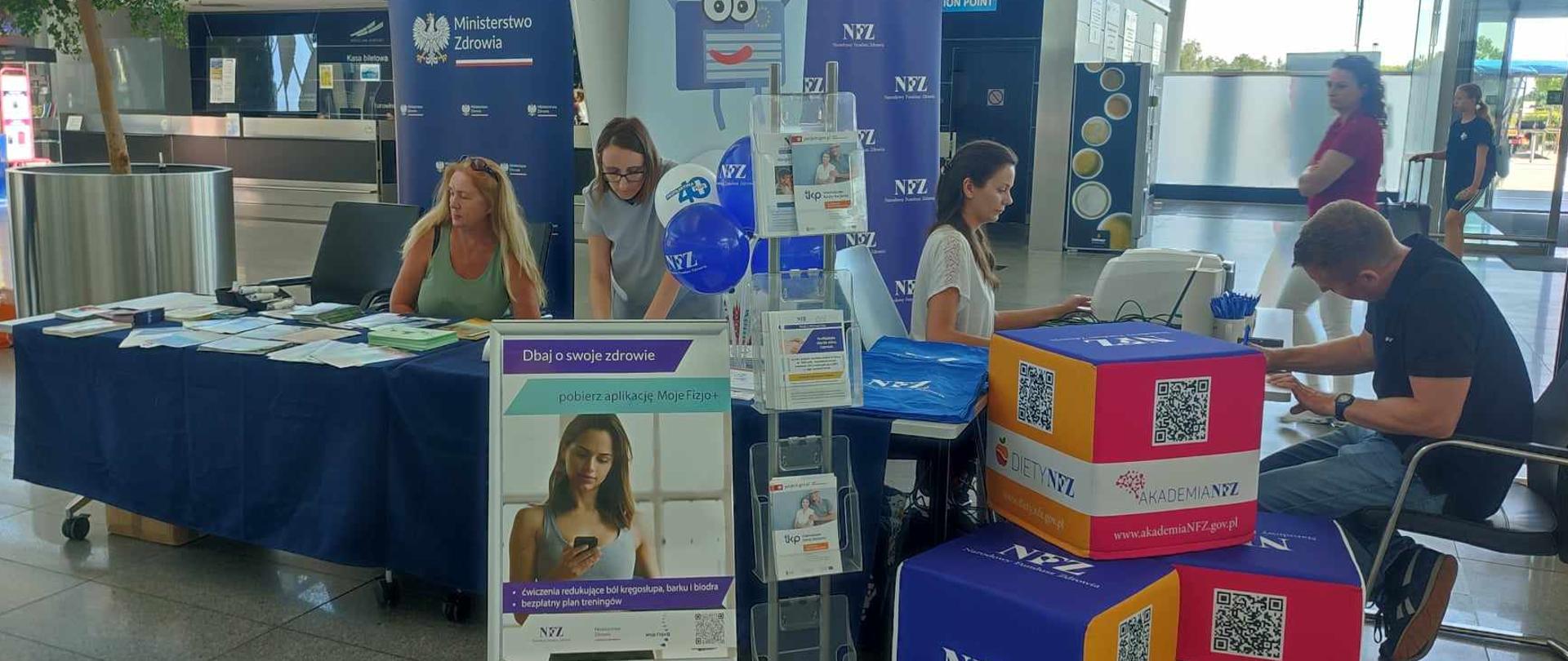 Stoliki z konsultantami oraz materiały promocyjne rozłożone wokoło nich