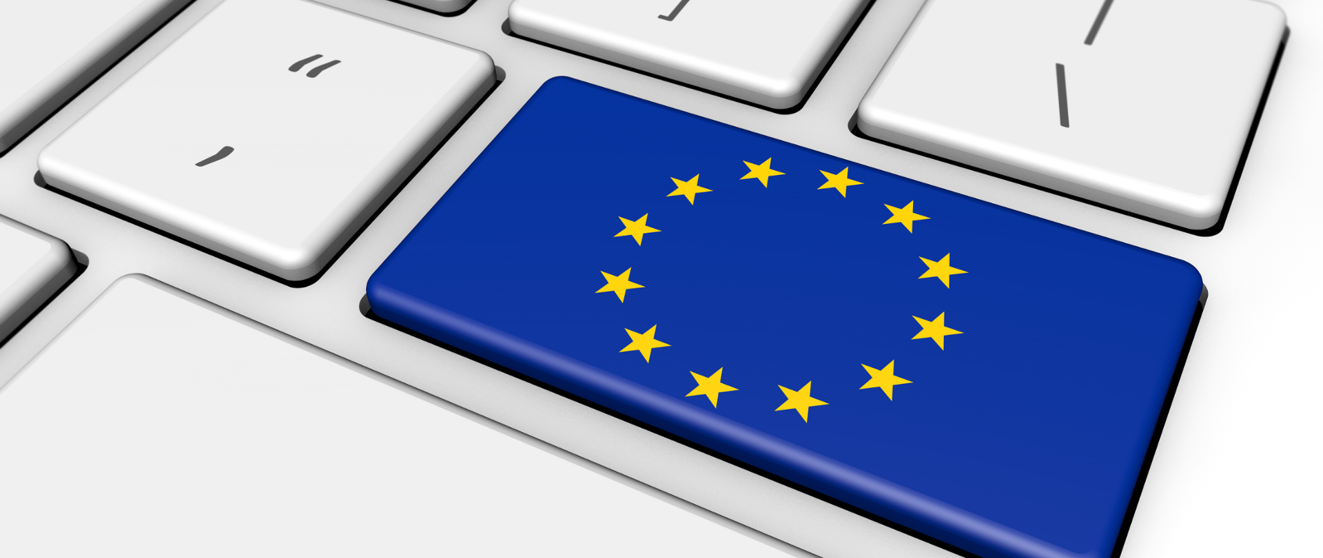 Biała klawiatura komputera, na jednym z przycisków flaga Unii Europejskiej