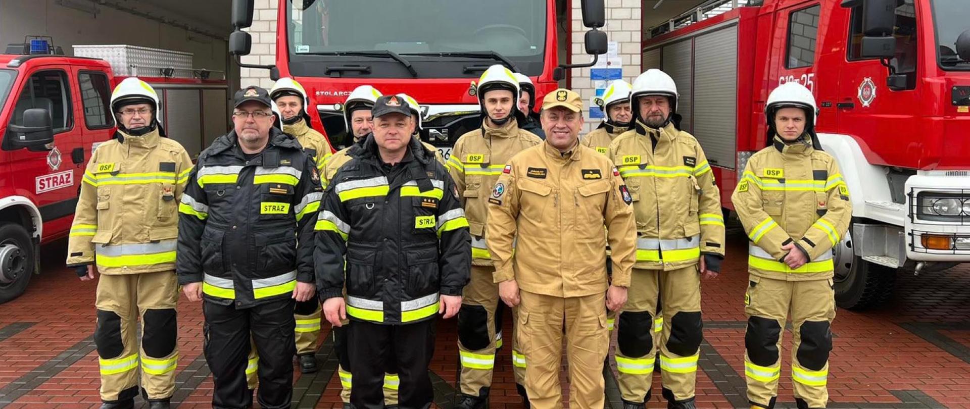 Zdjęcie przed budynkiem na tle wozów strażackich Mazowieckiego Komendanta Wojewódzkiego PSP nadbrygadiera Jarosław Nowosielski wraz z druhami z Ochotniczej Straży Pożarnej Winnica