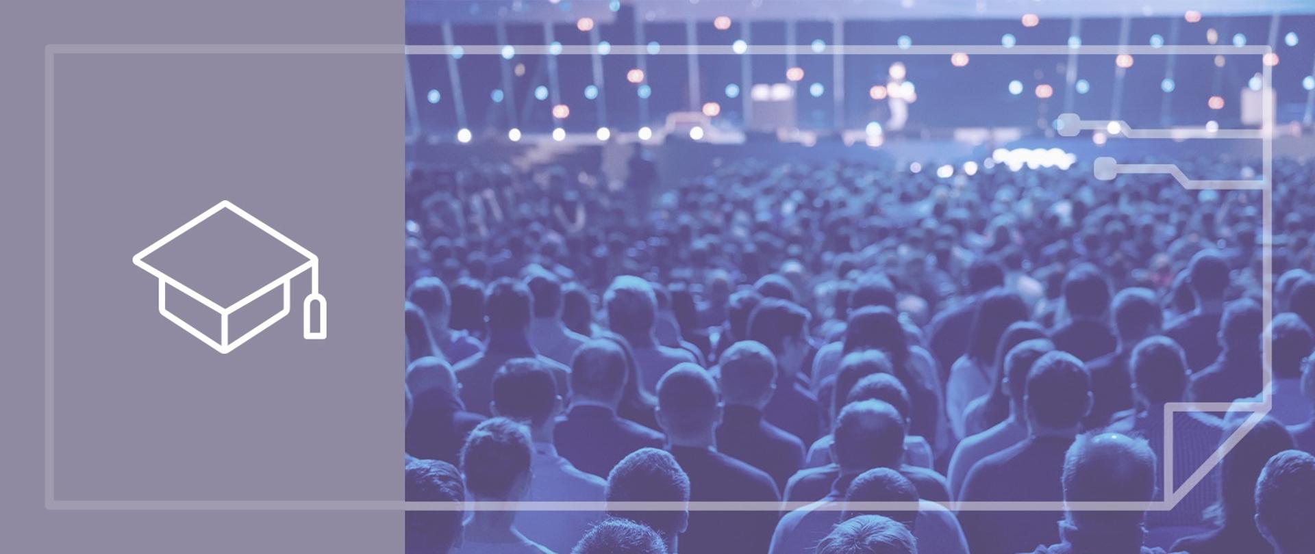 Sala konferencyjna na której siedzi kilkaset osób. Wszystkie głowy zwrócone ku scenie na której znajduje się prelegent. Ściana za prelegentem oświetlona wieloma punktami świetlnymi w różnych kolorach.