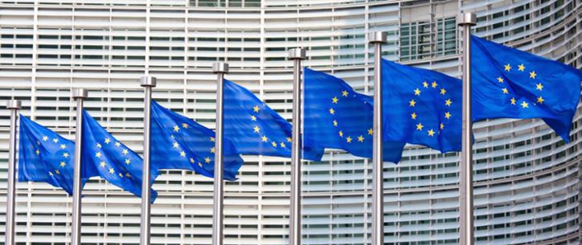 Flagi unijne na tle nowoczesnego budynku