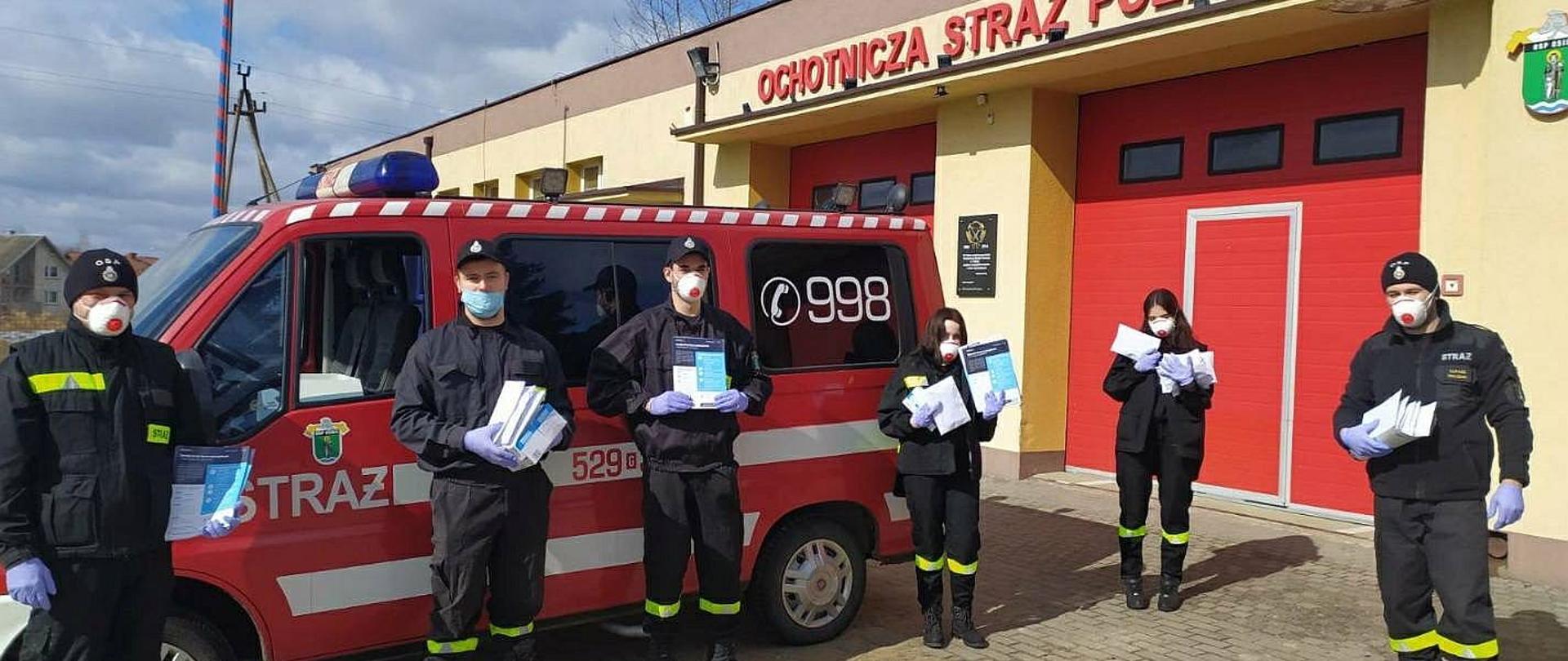 Fotografia przedstawia strażaków OSP podczas prowadzenia akcji kolportażowej ulotek informacyjnych