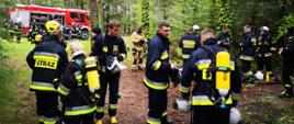 Druhowie OSP ubrani w ubrania specjalne, hełmy oraz sprzęt ochrony układu oddechowego tzw. aparaty oddechowe, podczas szkolenia.