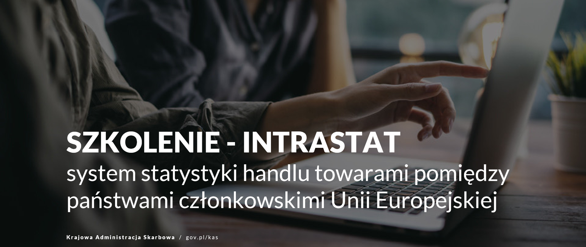 Dwie osoby siedzące przed laptopem. jedna wskzuje ręką ekran.