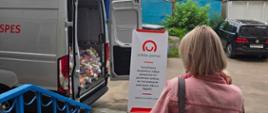 Women looking at the food packages with banner Polish Aid