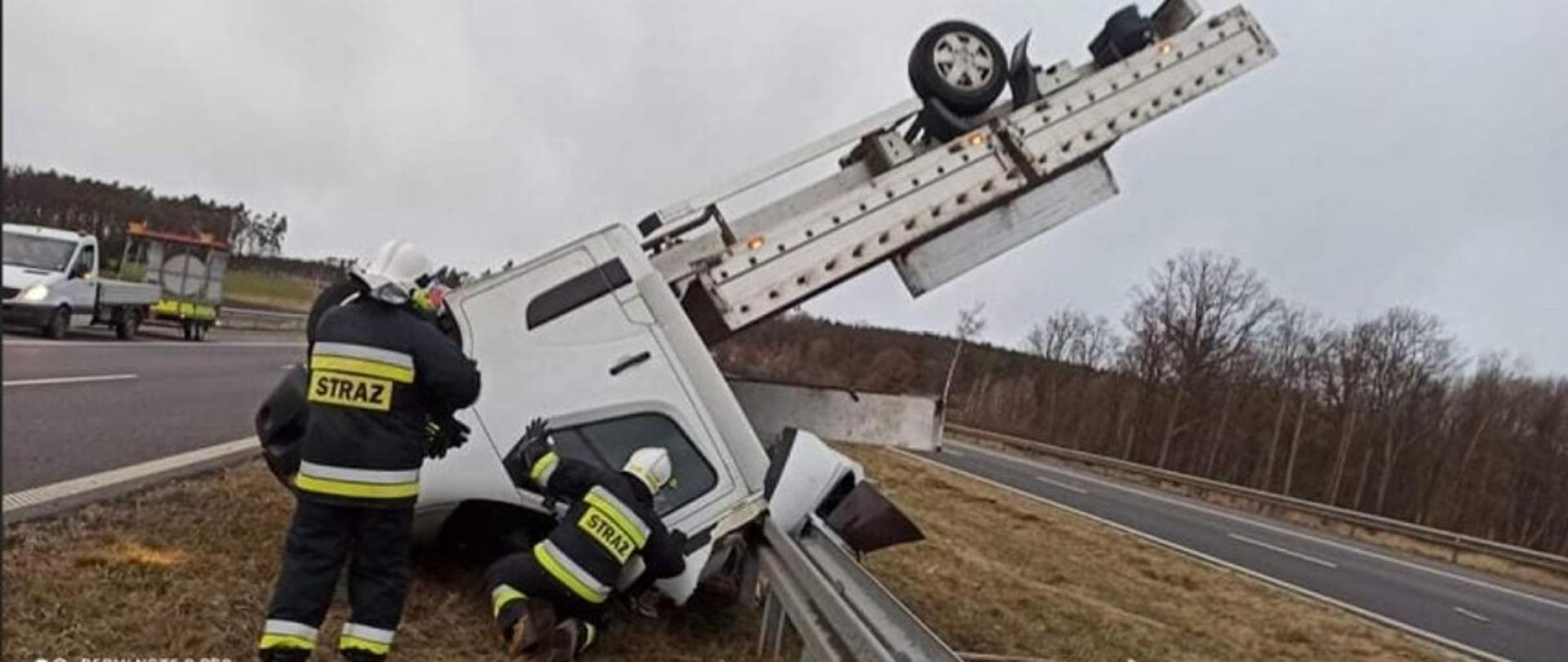 Wywrócony samochód i strazacy 