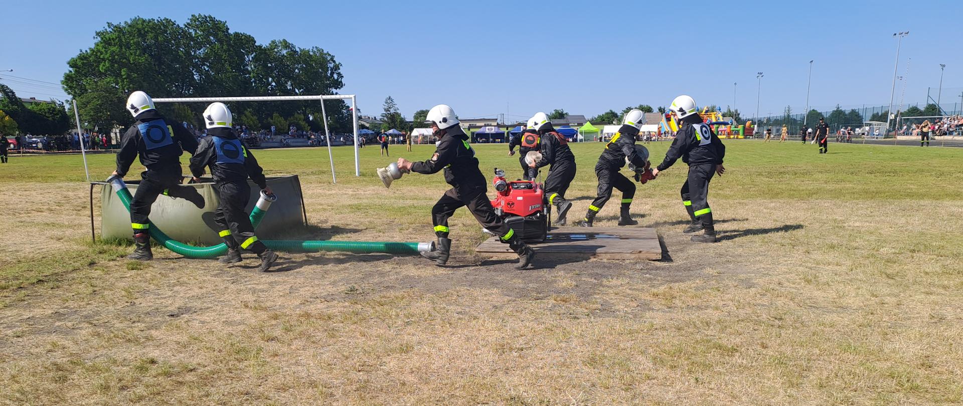 Zdjęcie przedstawia zawodników OSP podczas startu w zawodach sportowo-pożarniczych.