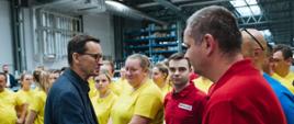 Premier ściska dłoń pracownika firmy.