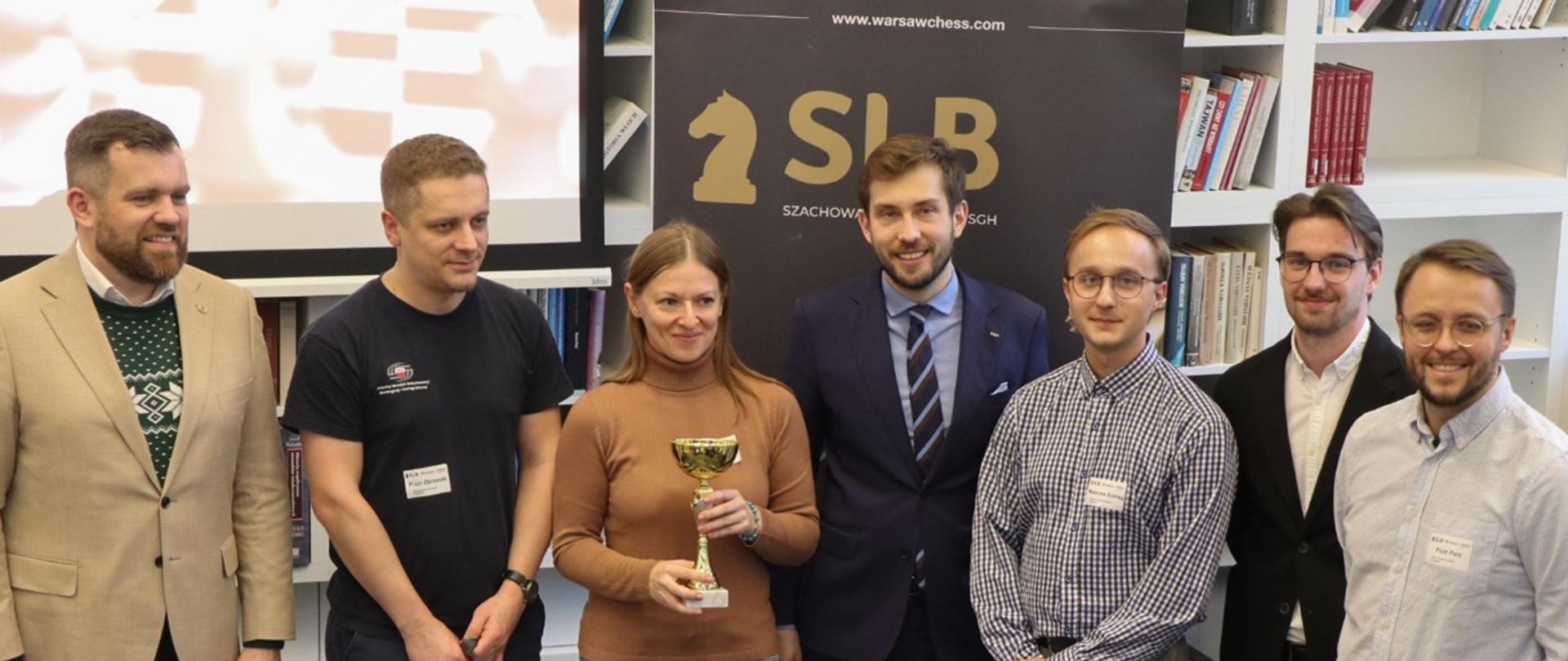 Zespół GUGiK Odbiera nagrodę za zajęcie 2 miejsca w sezonie jesień 2025 w towarzystwie organizatorów i sekretarza generalnego FIDE. Od lewej: Łukasz Turlej - sekretarz generalny FIDE, Piotr Zbrzeski, Agata Trybuła, Piotr Czajkowski - organizator, Mateusz Szeląg, Antoni Loba - organizator, Piotr Perz. 