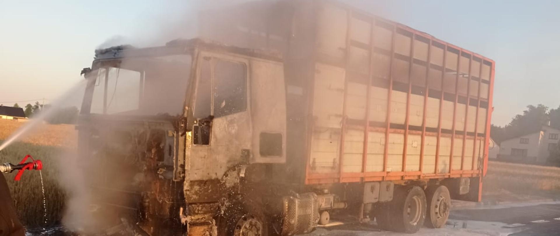 Strażak gasi kabinę samochodu ciężarowego