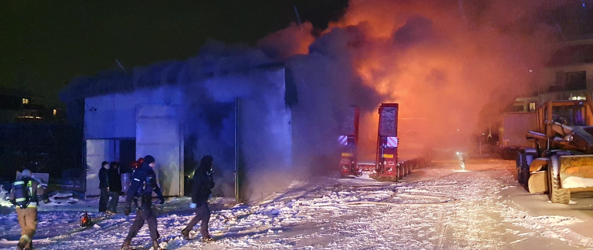 Pożar magazynu w tle policja i strażacy