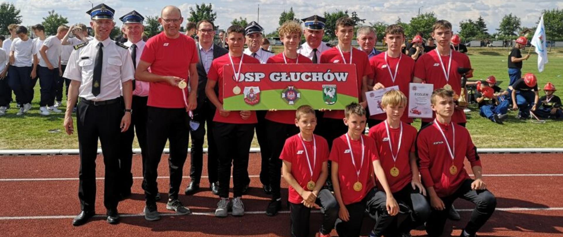 zdjecie grupowe na boisku zawodników i strażaków
