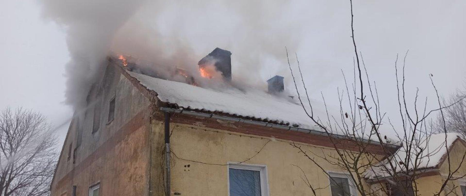 Budynek mieszkalny wielorodzinny z widocznym pożarem dachu