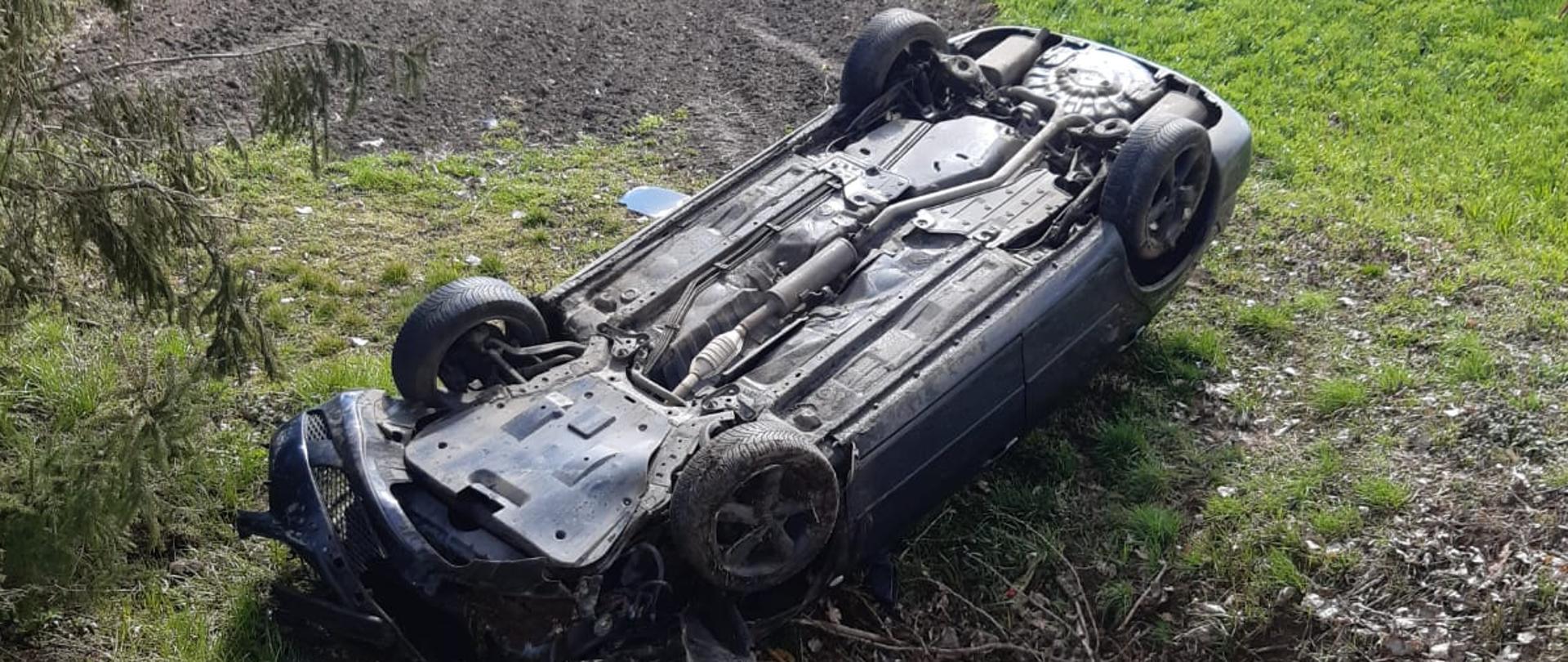 Zdjęcie przedstawia samochód leżący na dachu.