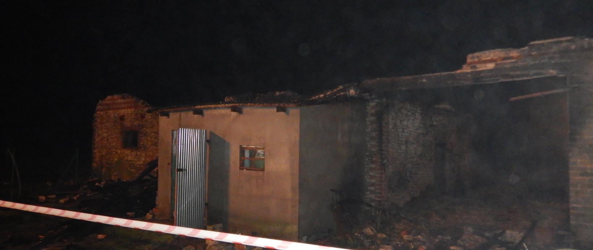 Zdjęcie przedstawia spalony budynek gospodarczy.