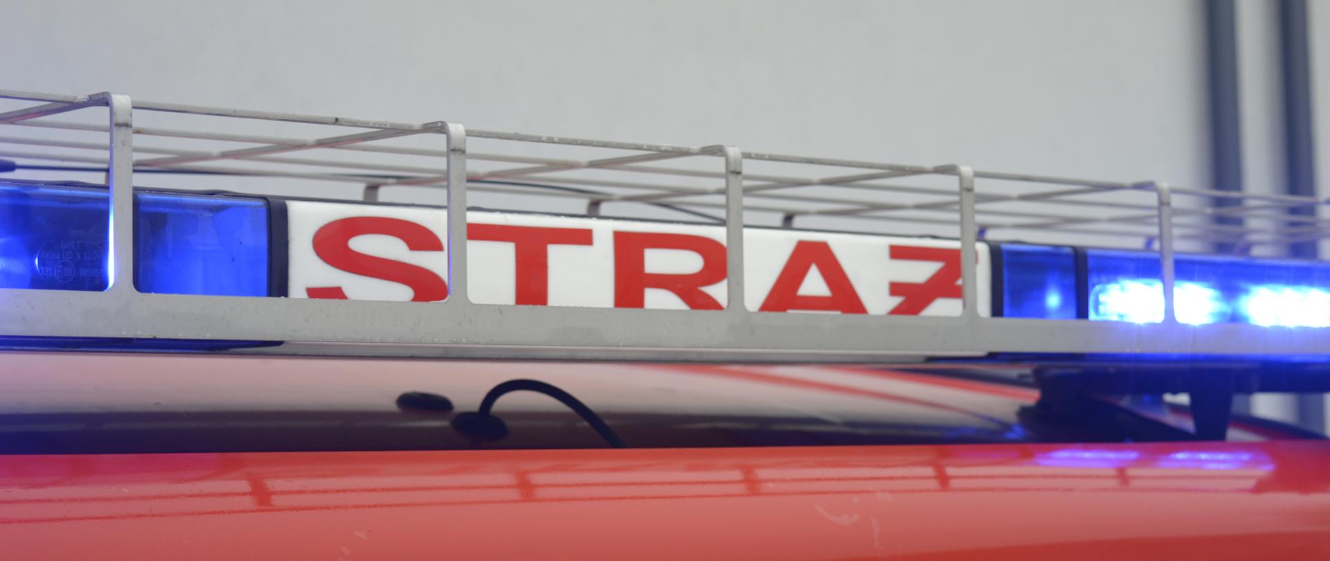 Na zdjęciu znajduje się belka z sygnałami świetlnymi i napisem STRAŻ