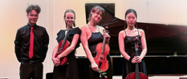 Czworo uśmiechniętych młodych ludzi stojących w swobodnych pozach na tle fortepianu. Widoczne sylwetki od głowy do wysokości ud. Z lewej strony mężczyzna ubrany na czarno z czerwonym krawatem. Kobiety w czarnych sukienkach, trzymają instrumenty muzyczne: skrzypce, altówkę i wiolonczelę. W tle biała ściana.