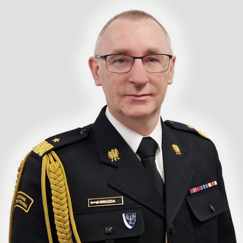 Zdjęcie przedstawia nadbrygadiera Janusza Drozdę Lubuskiego Komendanta Wojewódzkiego PSP w Gorzowie Wlkp.w mundurze na szarym tle.
