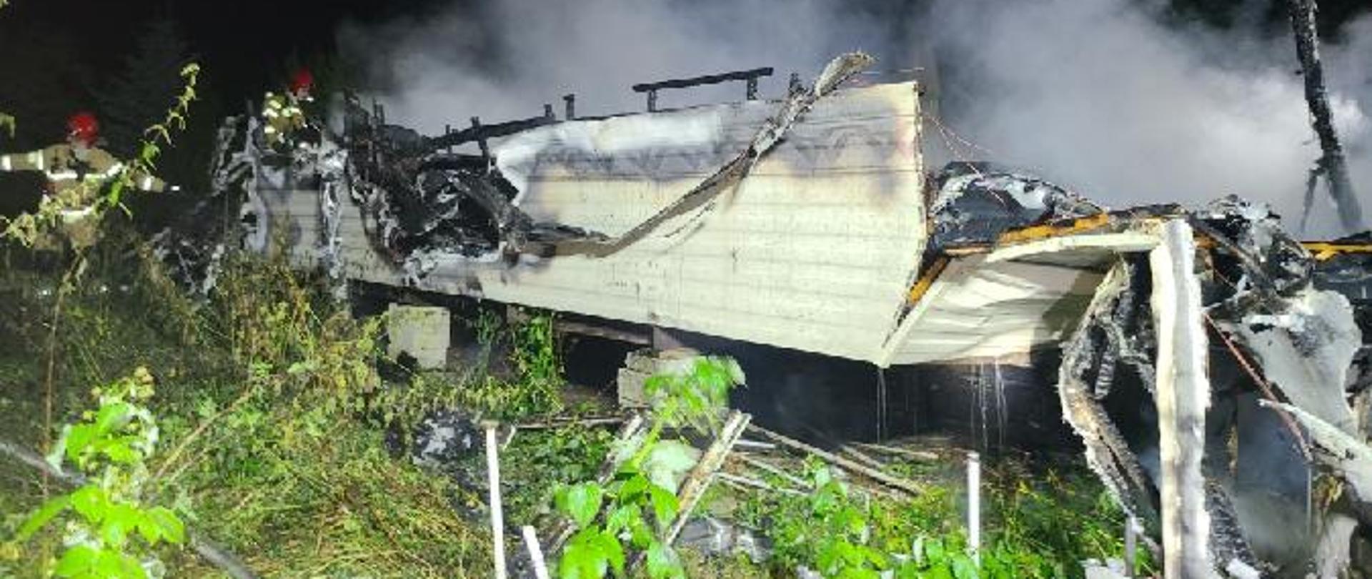 Zdjęcie przedstawia zgliszcza spalonej przyczepy kempingowej typu holenderskiego.