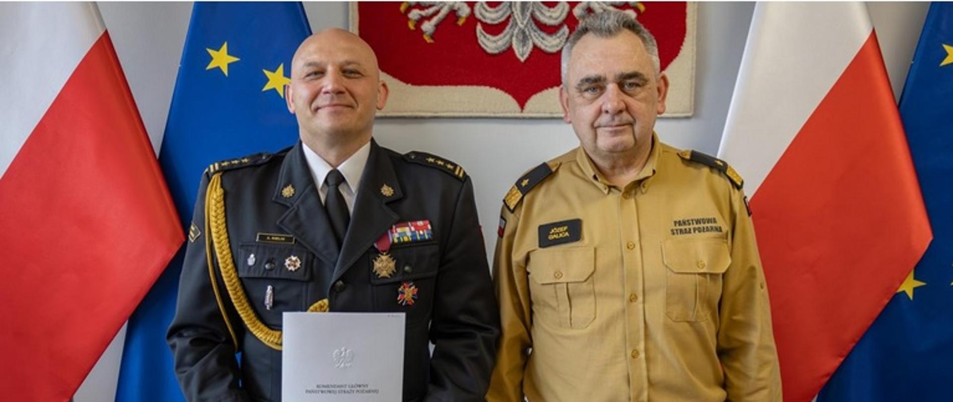st. bryg. dr inż. Arkadiusz Kielin po lewej stronie stoi z aktem powołania na stanowisko Zastępcy Małopolskiego Komendanta Wojewódzkiego Państwowej Straży Pożarnej obok po prawej stronie zastępca komendanta głównego PSP nadbryg. Józef Galica.