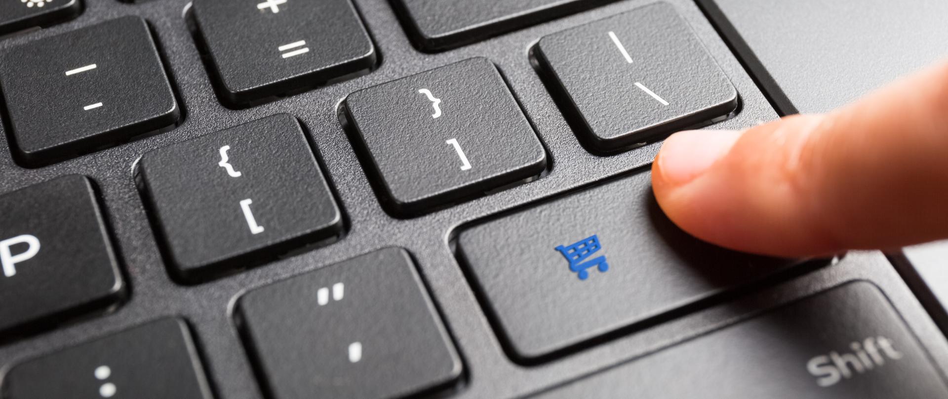 Palec wciskający na klawiaturze przycisk z symbolem zakupów