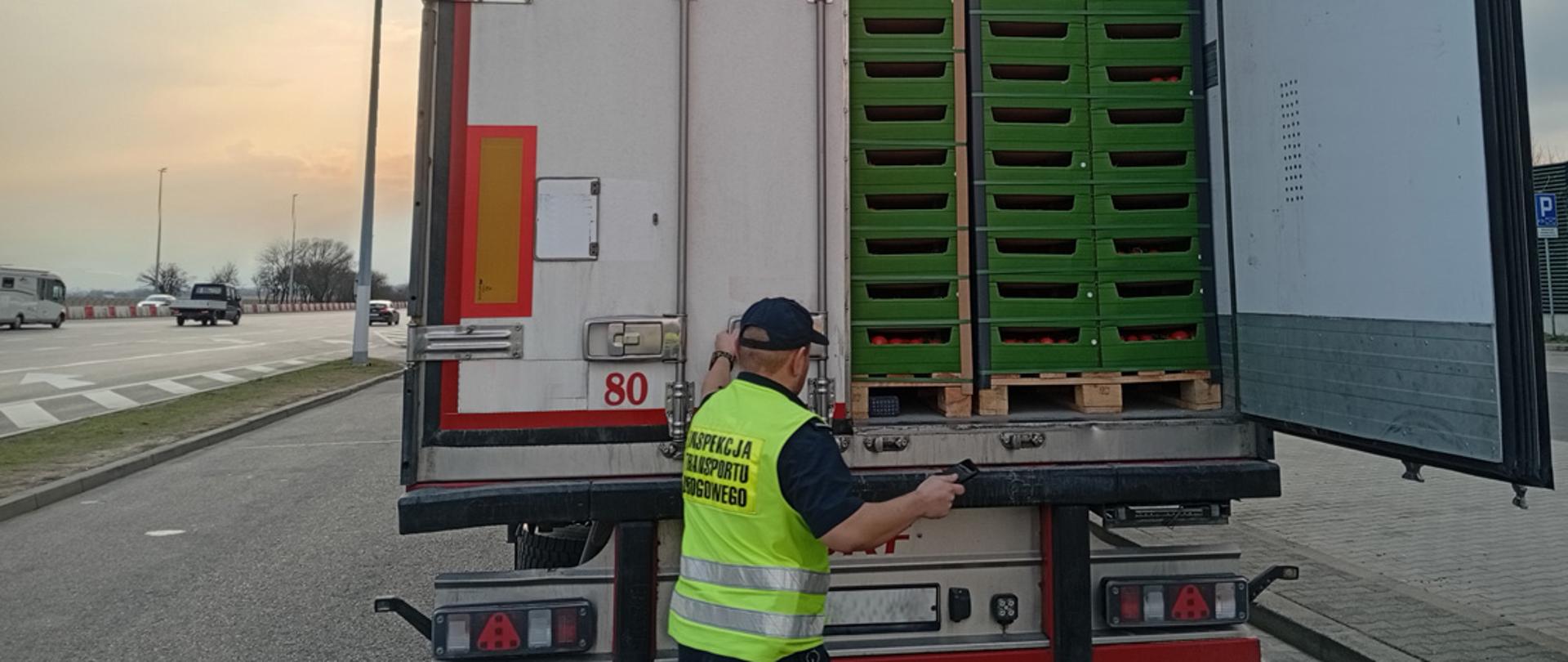 Inspektor transportu drogowego otwierający naczepę z pomidorami podczas kontroli na autostradzie A4
