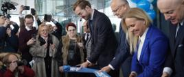 Wiceminister Jan Szyszko przecina wstęgę podczas otwarcia dworca w Lublinie, wiceminister trzyma w dłoniach wstęgę i nożyczki, po jego prawej stronie stoi prezydent Lublina Krzysztof Żuk
