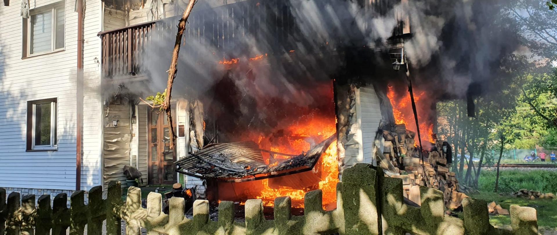 Pożar budynku mieszkalnego w Żywcu - płomienie i ogień wydostają się z pomieszczenia garażu. 