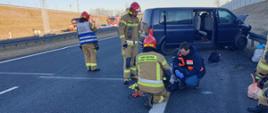 Strażacy udzielają pomocy medycznej poszkodowanym w wypadku.