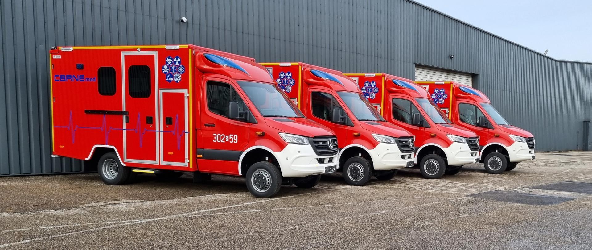cztery czerwone samochody mercedes z czerwoną naczepą z napisem CBRNE med 
