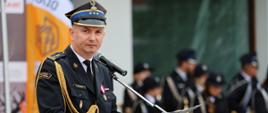 Komendant Powiatowy Państwowej Straży Pożarnej w Ciechanowie przy mównicy podczas swojego przemówienia 