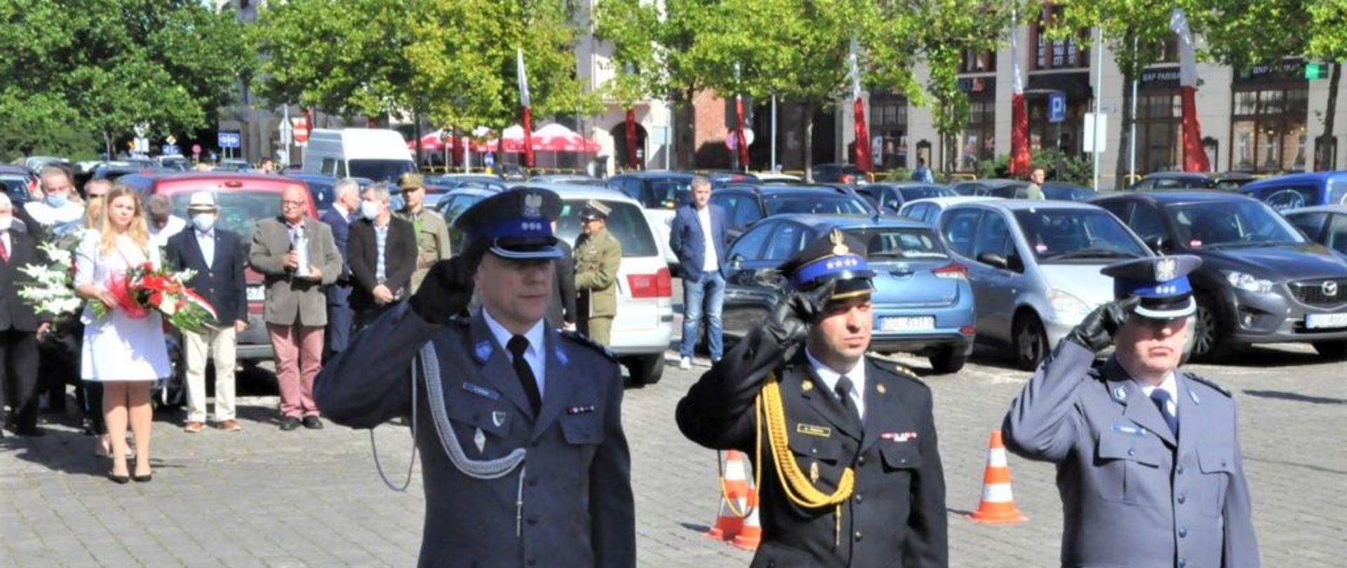 Zdjęcie przedstawia Komendant Mojskiego PSP oraz funkcjonariuszy policji oddających chłód w 81 rocznica wybuchu II wojny światowej. Wszyscy ubrani w mundur galowy