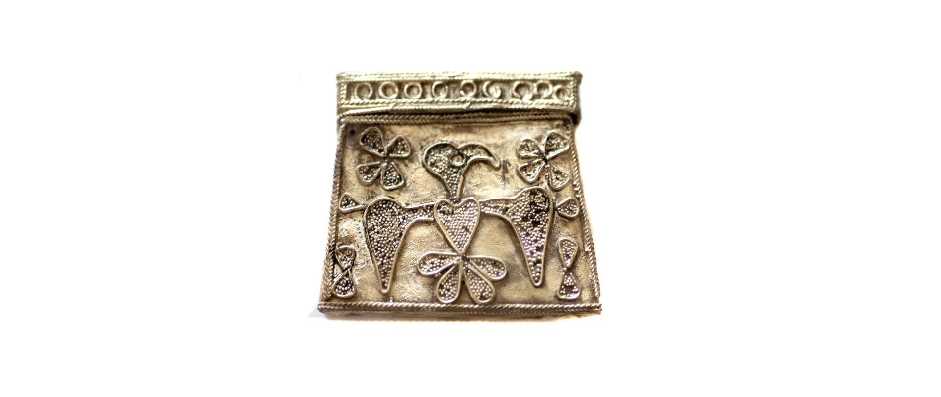 srebrna kaptorga (pojemnik, w którym umieszczano amulety, pachnidła a w późniejszym okresie relikwie) z wyobrażeniem drapieżnego ptaka (orła?) z XI-XII w.