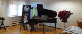 Zdjęcie przedstawia uczennicę grającą na fortepianie podczas koncertu absolwentów PSM I stopnia w Jarocinie.