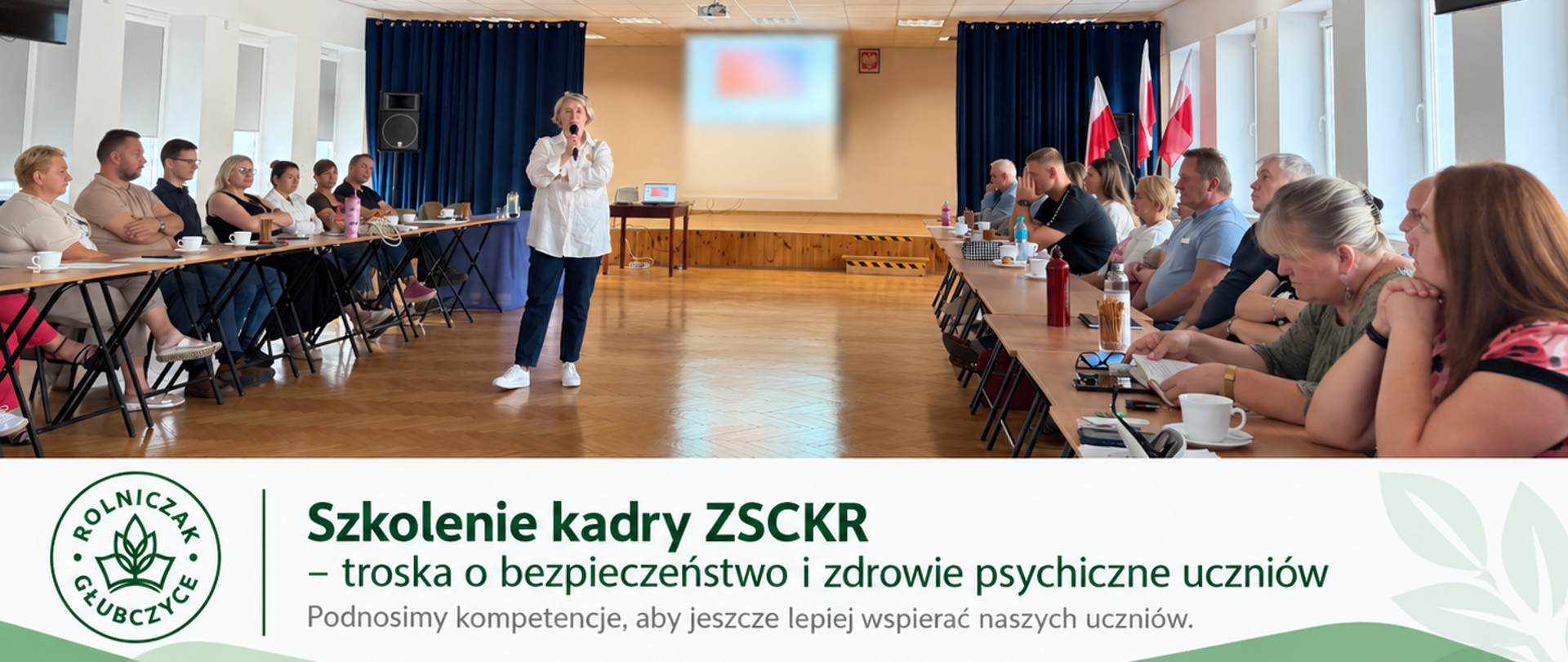 Kadra ZSCKR podczas szkolenia dotyczącego rozpoznawania kryzysów psychicznych młodzieży i zasad właściwego reagowania. W sali szkoleniowej prowadząca przemawia do uczestników siedzących przy stołach, a w tle znajduje się ekran prezentacji.