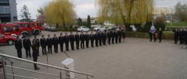 Zdjęcie przedstawia strażaków stojących na placu przed Komendą podczas wręczenia promes